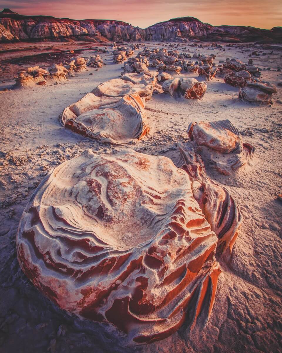 Bisti badlands rock formations are weird and wild. It's sandy colored with deep orange hues thrown in. 
