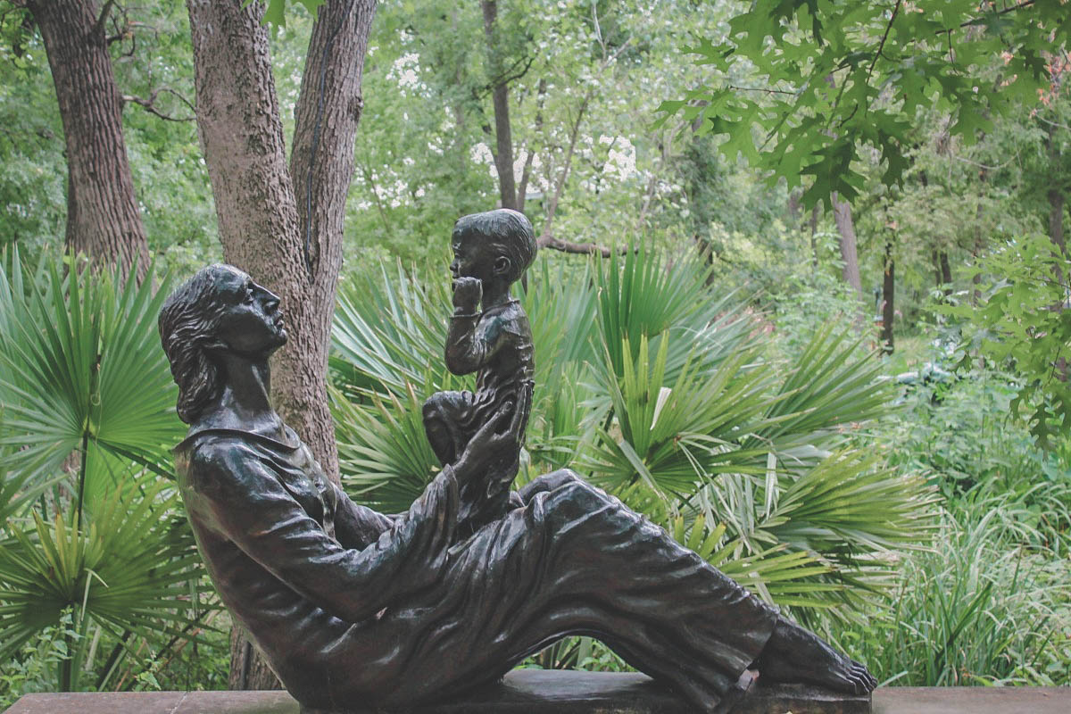 A mother looking at her son statue in Umlauf Sculpture Garden