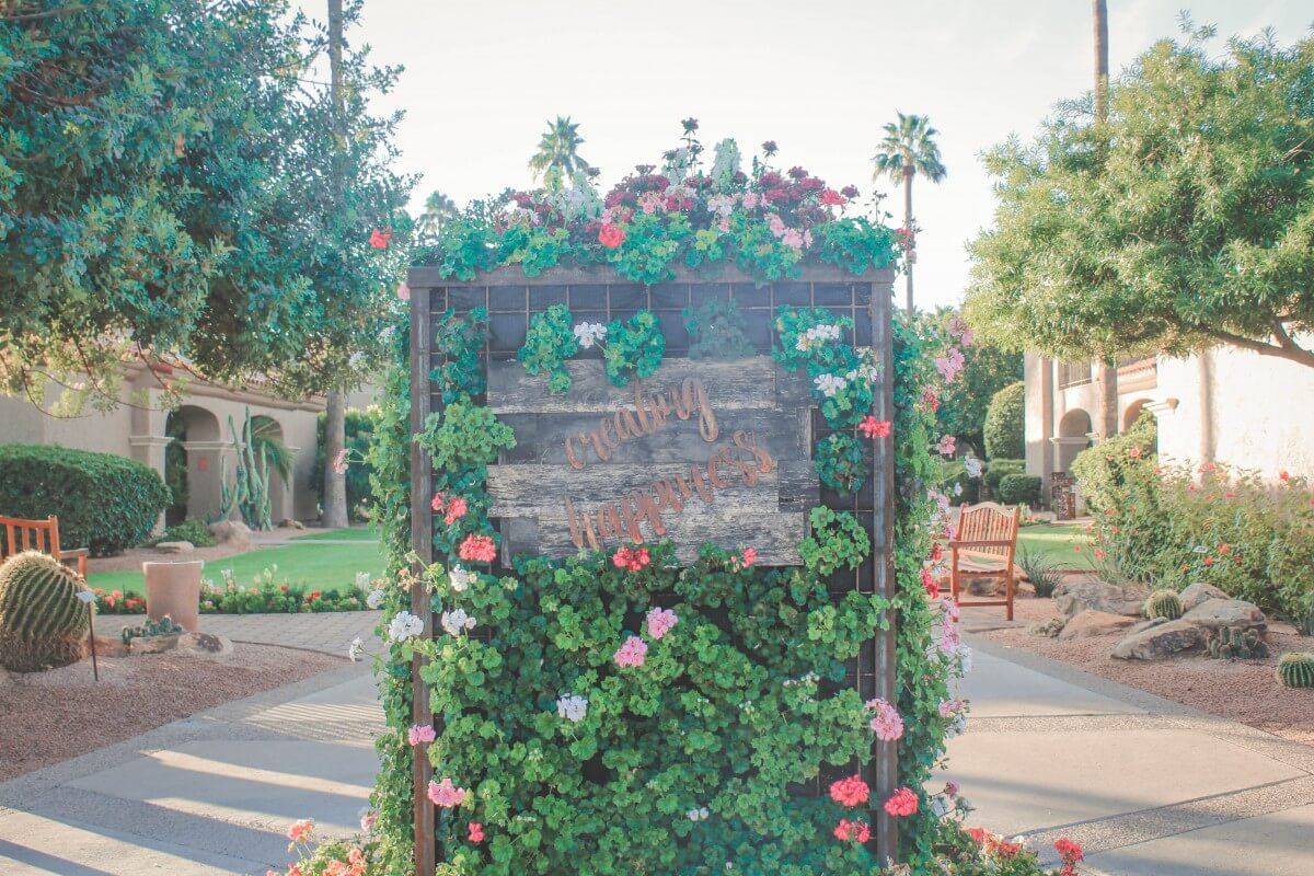 The Plaza Resort in Scottsdale garden pathway with a creating happiness sign. 