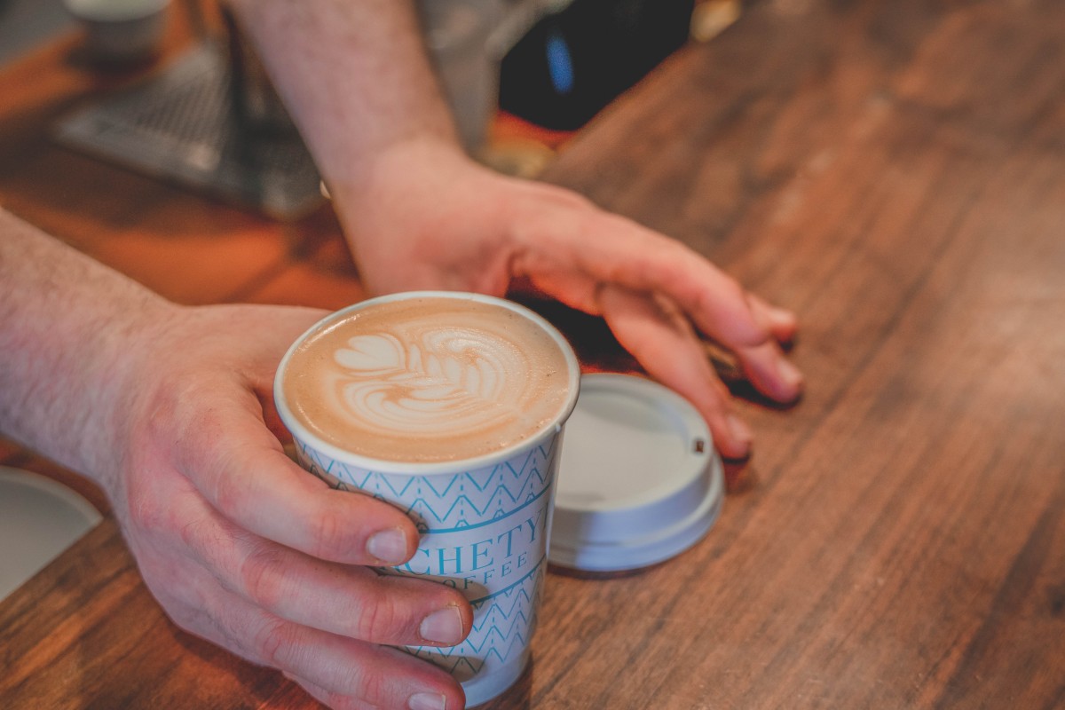 Person holding out a cup of Archetype Coffee in Omaha