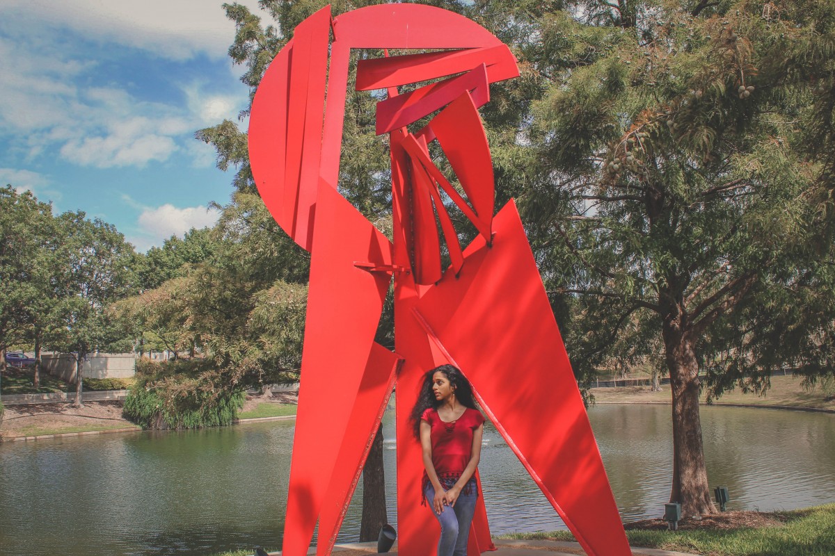person in front of Texas Sculpture Garden red sculpture in Frisco