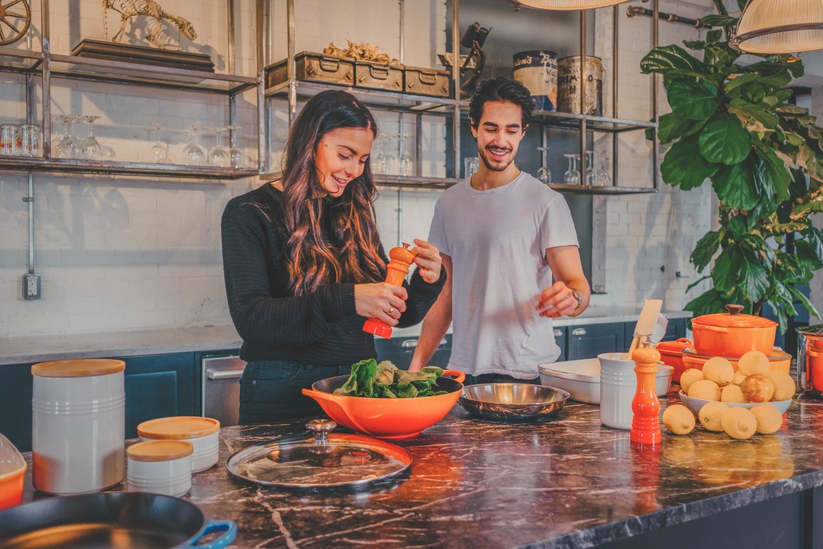 couple making a salad during their at home cooking class