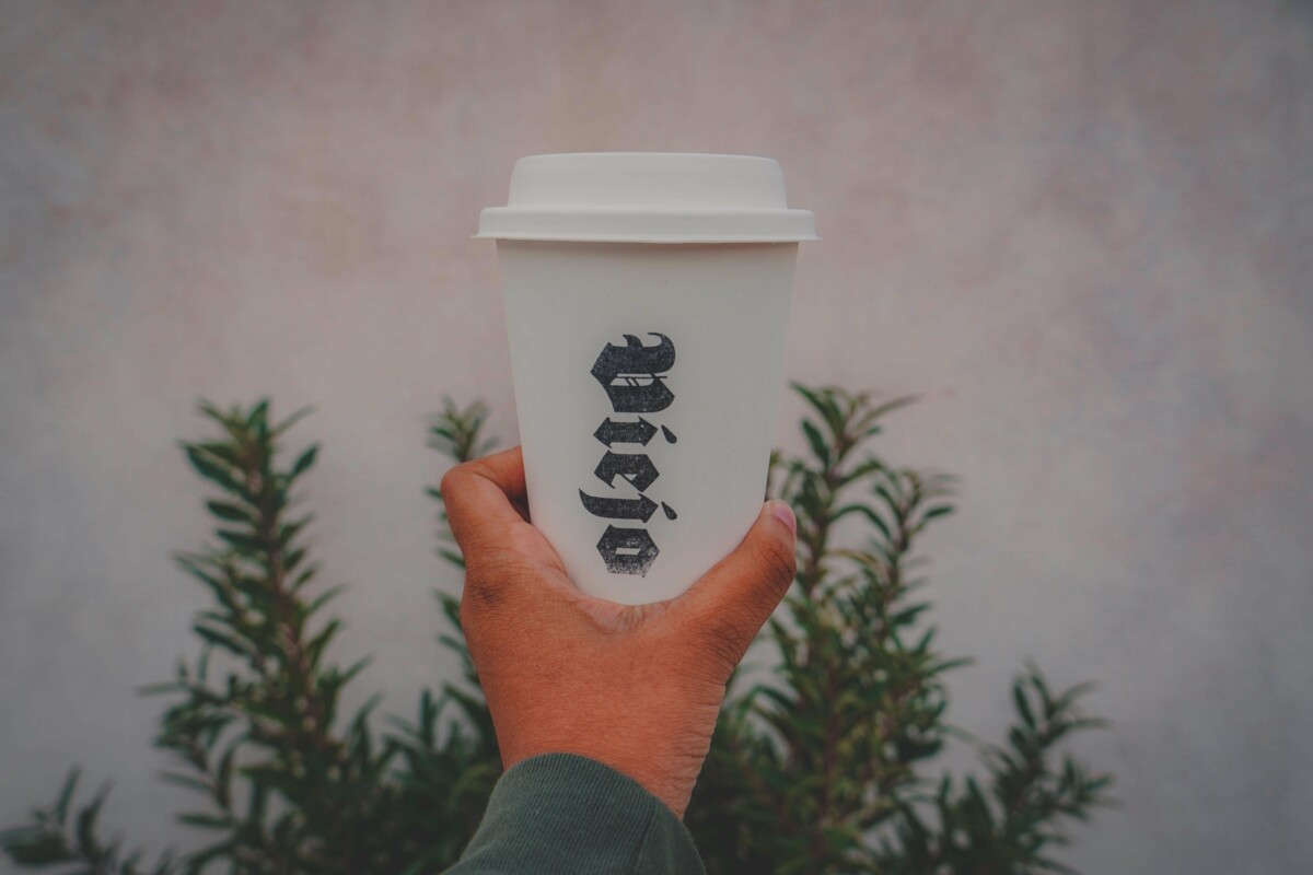 holding up a cup of Viejo Coffee, coffee from one of the best coffee shops in El Paso