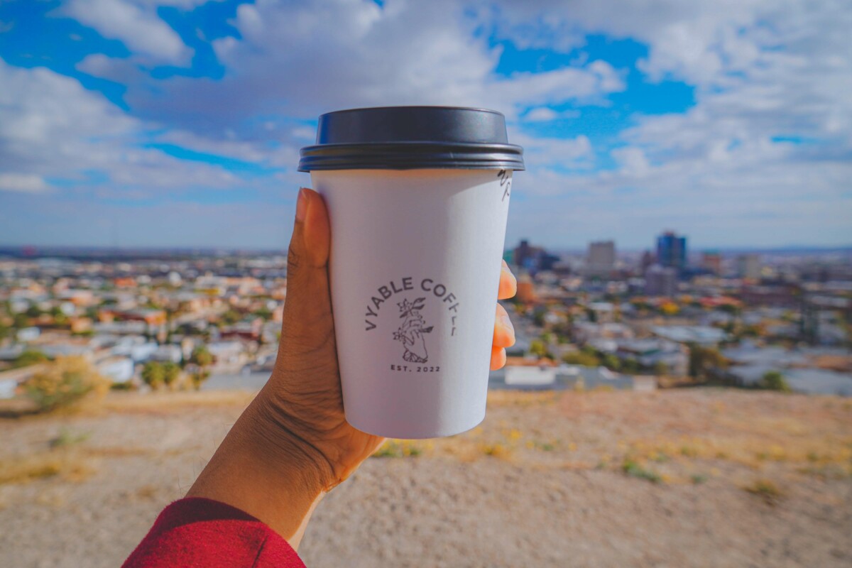 holding up a cup of Vyable Coffee in El Paso