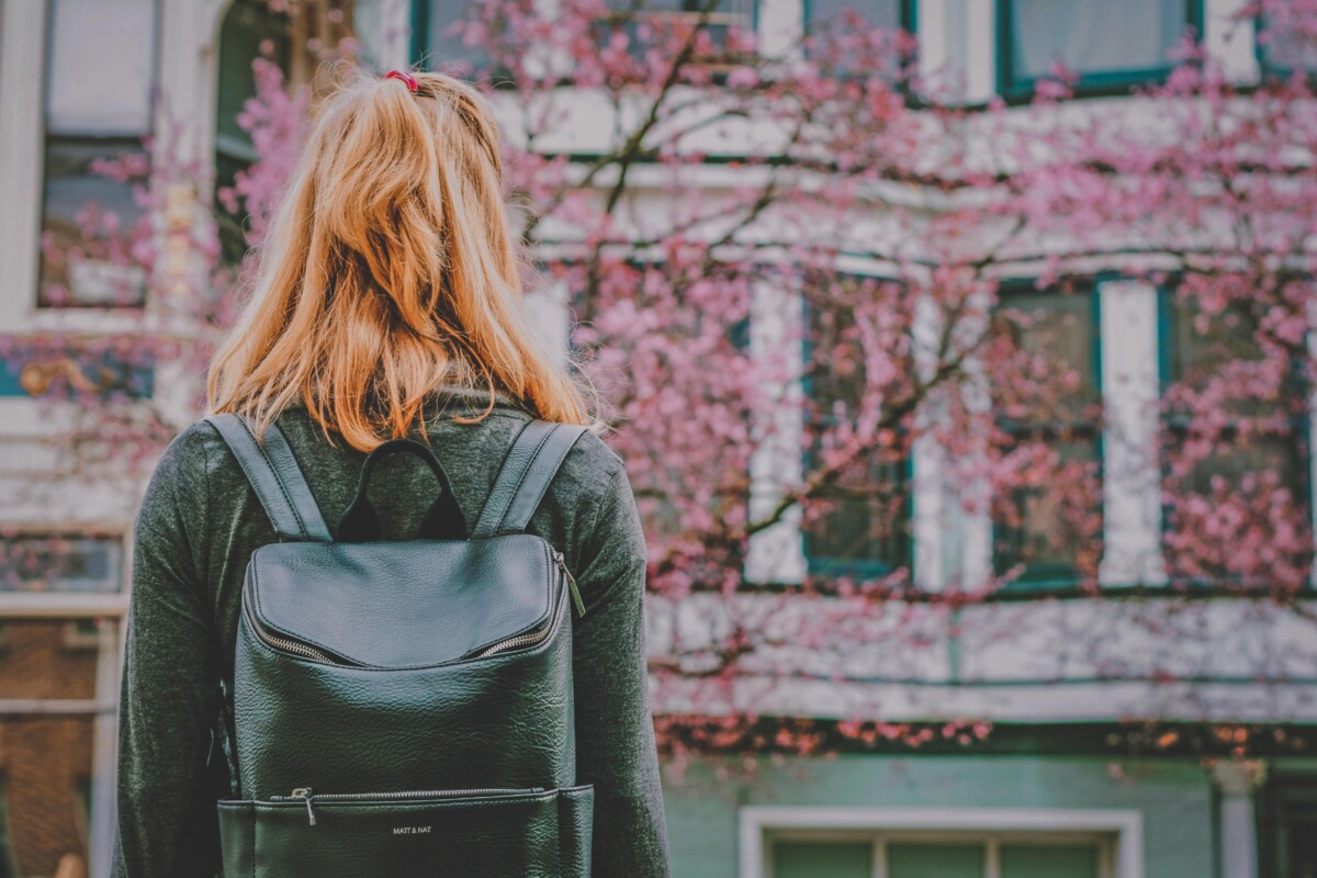 San Francisco Packing List Essentials featured photo of a girl with day bag facing the Painted Ladies in SF