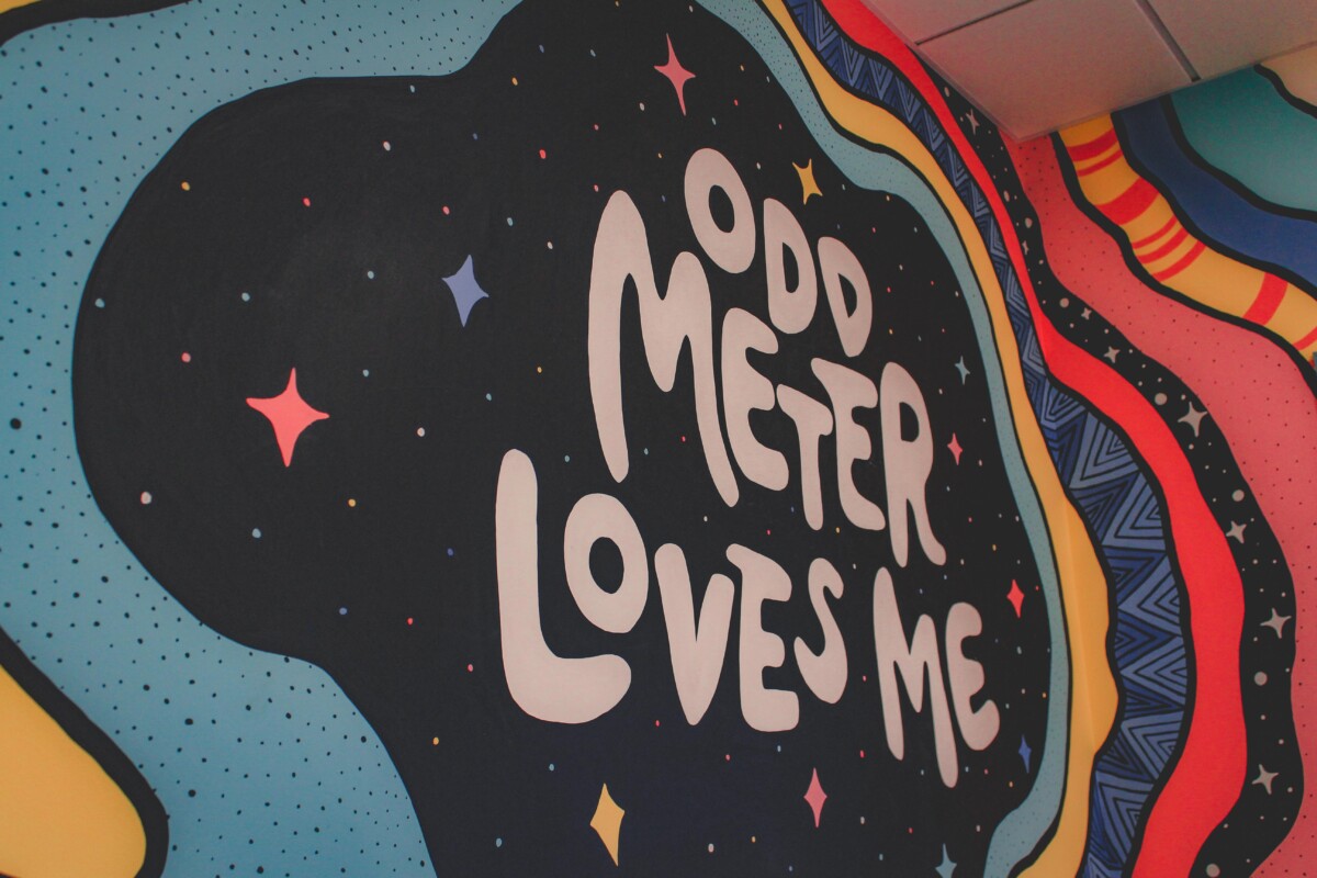 wall that says Odd Meter Loves Me to symbolize the positive vibes of Odd Meter Coffee
