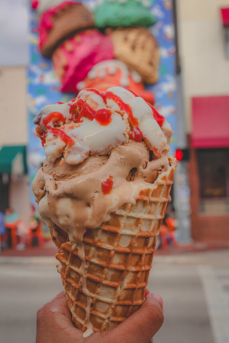 holding up a dripping double scoop Abuela Maria ice cream in front of Azucar Ice Cream Company